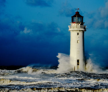 A,Resilient,Lighthouse,Standing,Up,To,Crashing,Waves,During,A